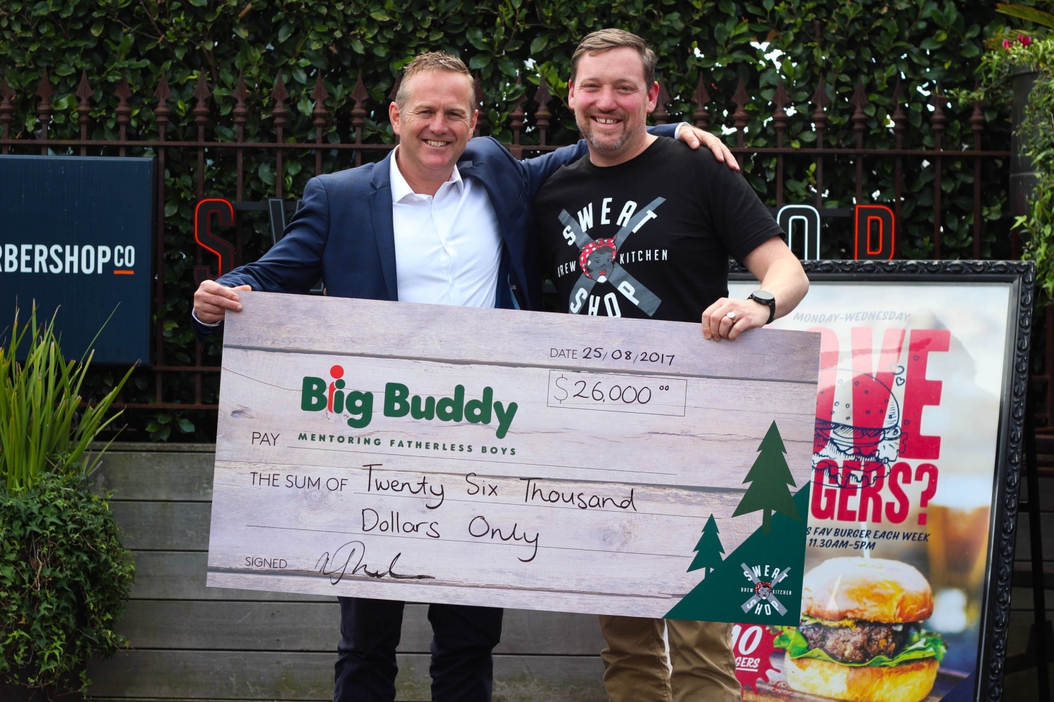 Big Buddy Chair Travis Field accepts fundraising cheque from Barworks Sweatshop