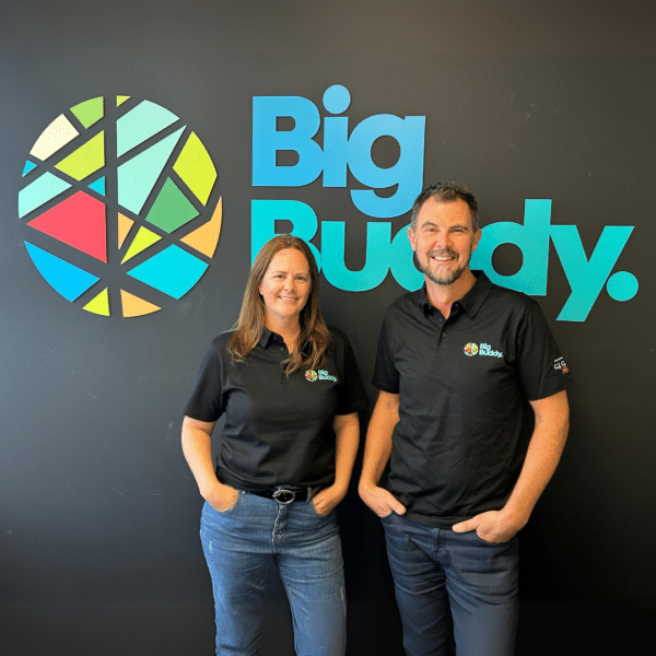 Christie Stewart and Steve Sobota standing together under the big buddy logo