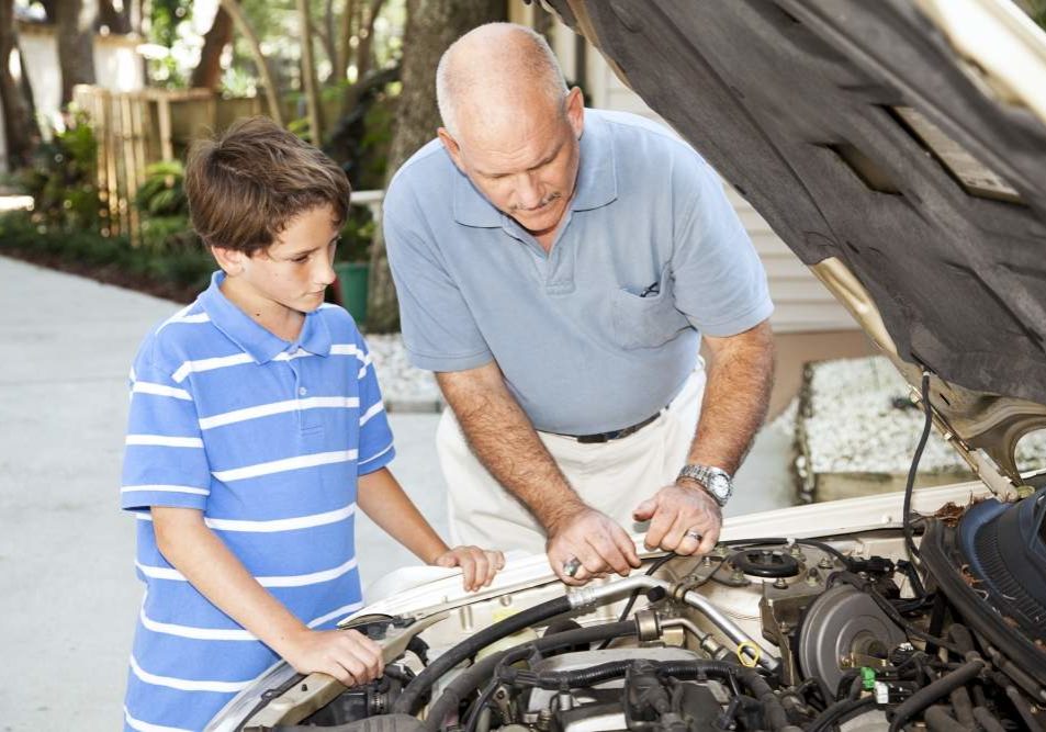man helping boy car engine