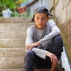 sad teenage boy with cap on